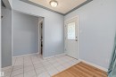 Entryway featuring a decorative glass panel door, light tile flooring, wood-finish flooring transition, and a flush mount ceiling light - 13320 123 Street Nw, Edmonton, AB  - Indoor Photo Showing Other Room 