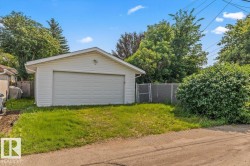 Detached two-car garage with white siding, gable roof, and concrete apron - 