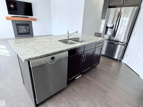 7819 173 Avenue Nw, Edmonton, AB - Indoor Photo Showing Kitchen With Fireplace With Stainless Steel Kitchen With Double Sink
