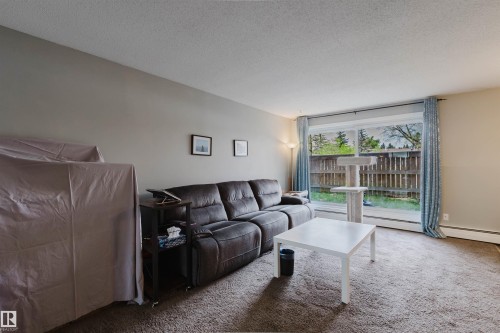 Sliding glass door leading to a private outdoor space - #126 5125 Riverbend Rd Nw, Edmonton, AB 