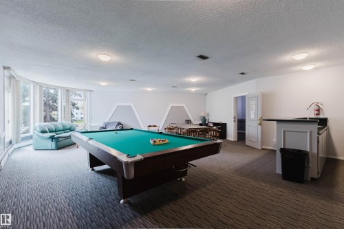 Recreational space featuring a pool table, built-in bar, extensive window line, and recessed lighting - #126 5125 Riverbend Rd Nw, Edmonton, AB 