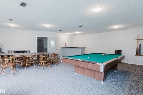 Recessed lighting, light gray wall paint, built-in bar, and two-tone carpet flooring - #126 5125 Riverbend Rd Nw, Edmonton, AB 