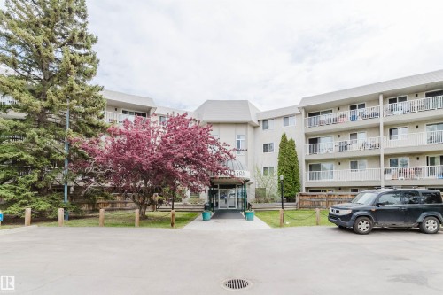 Multi-level building with individual balconies and a prominent central entrance - #126 5125 Riverbend Rd Nw, Edmonton, AB 
