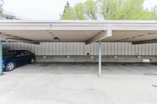Covered parking structure with designated spaces and concrete flooring - #126 5125 Riverbend Rd Nw, Edmonton, AB 