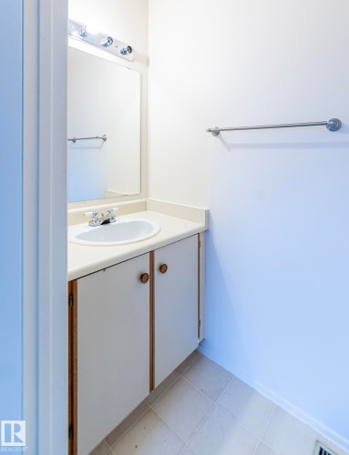 Bathroom vanity with an integrated sink, polished chrome faucet, and a wall-mounted mirror - #4 3221 119 St Nw, Edmonton, AB 