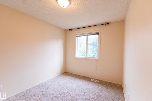 Neutral-toned walls, carpeted flooring, and a flush mount ceiling light - #4 3221 119 St Nw, Edmonton, AB 