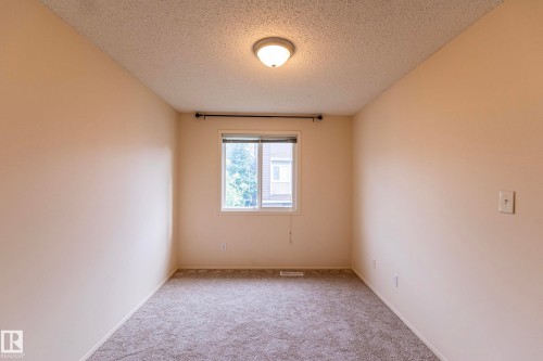 Recessed window with natural light, neutral wall colors, textured ceiling, and carpeted flooring - #4 3221 119 St Nw, Edmonton, AB 
