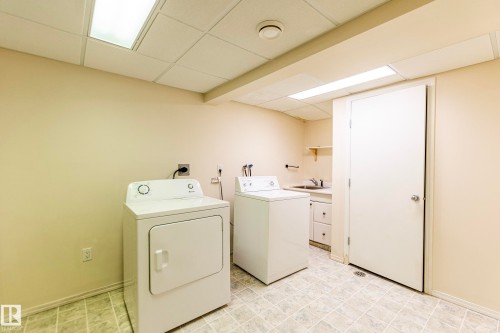 Dedicated utility area featuring a sink, cabinet storage, and functional tile flooring - #4 3221 119 St Nw, Edmonton, AB 