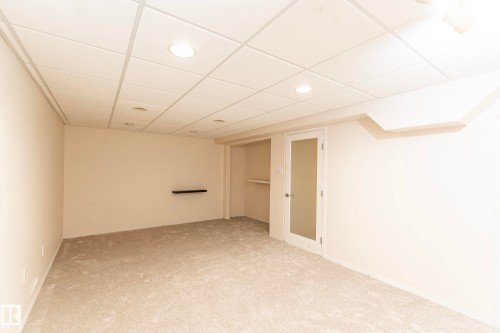Recessed lighting, drop ceiling, wall-to-wall carpeting, built-in shelving, and a frosted glass door - #4 3221 119 St Nw, Edmonton, AB 
