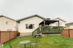 Private wooden deck featuring a gazebo, green painted railings, and lattice skirting - 