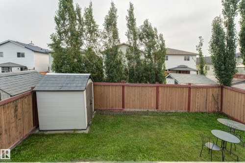 Fenced backyard featuring a manicured lawn and two storage sheds - 3519 22 Street Nw, Edmonton, AB 