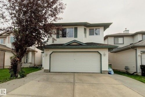 Two-story residence featuring white siding and a prominent two-car garage - 3519 22 Street Nw, Edmonton, AB 