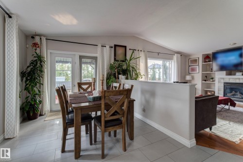 Dining area with light gray tile flooring, vaulted ceiling, and double glass-paned doors - 3519 22 Street Nw, Edmonton, AB 