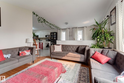 Wood-finish flooring throughout, with a partial wall separating living area from kitchen - 3519 22 Street Nw, Edmonton, AB 