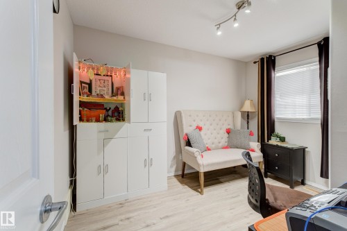 Recessed lighting fixture, light wood-finish flooring, built-in white cabinetry, window with blinds, and neutral wall paint - 3519 22 Street Nw, Edmonton, AB 