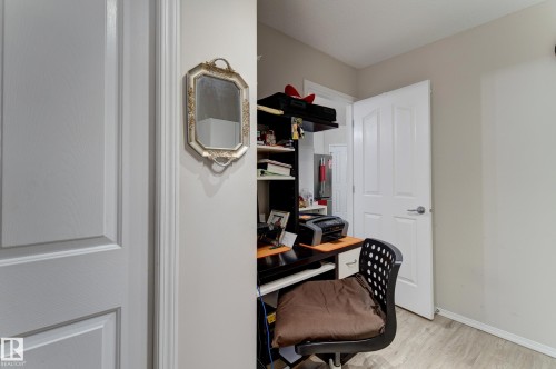Recessed workspace featuring built-in shelving, wood-finish flooring, and light neutral wall paint - 3519 22 Street Nw, Edmonton, AB 