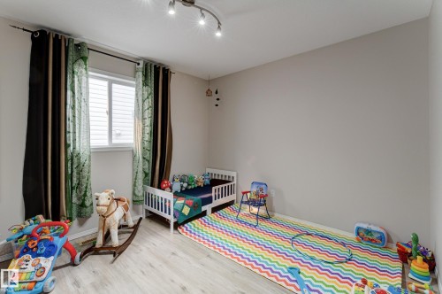 Recessed window with white blinds, wood-finish flooring, and track lighting - 3519 22 Street Nw, Edmonton, AB 