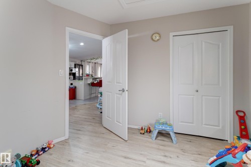 Wood-finish flooring, neutral wall paint, white interior doors, and a double-door closet - 3519 22 Street Nw, Edmonton, AB 