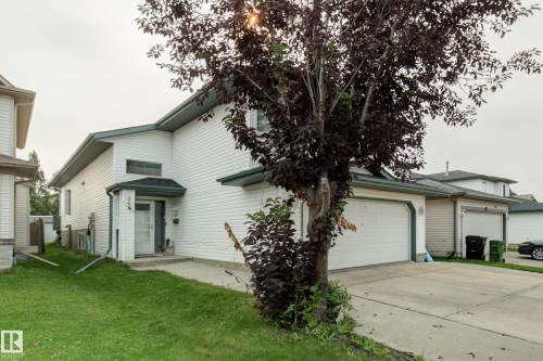 White siding exterior with a covered entry, attached garage, and a concrete driveway - 3519 22 Street Nw, Edmonton, AB 