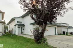 White siding exterior with a covered entry, attached garage, and a concrete driveway - 