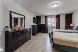 Light wood-finish flooring, white walls, and a multi-pane window - 