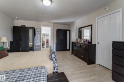 Wood-finish flooring with white trim and a ceiling-mounted light fixture - 