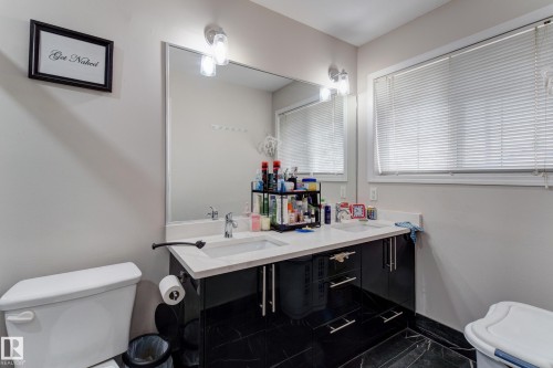Double vanity with white countertops, undermount sinks, and black cabinetry - 3519 22 Street Nw, Edmonton, AB 