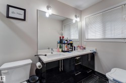 Double vanity with white countertops, undermount sinks, and black cabinetry - 