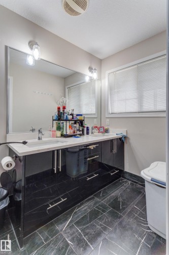 Double vanity with a white countertop and undermount sinks, set upon a black cabinet with metal pull hardware - 3519 22 Street Nw, Edmonton, AB 