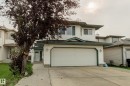 Two-story residence featuring light-colored siding, a two-car garage, and a concrete driveway - 3519 22 Street Nw, Edmonton, AB 