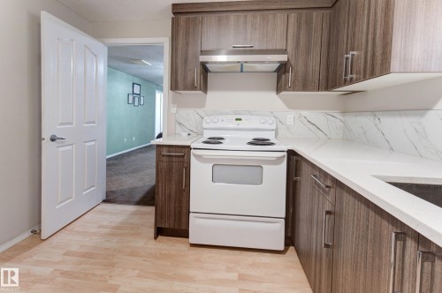 Kitchen featuring wood-finish cabinetry, white countertops, and a white range - 3519 22 Street Nw, Edmonton, AB 