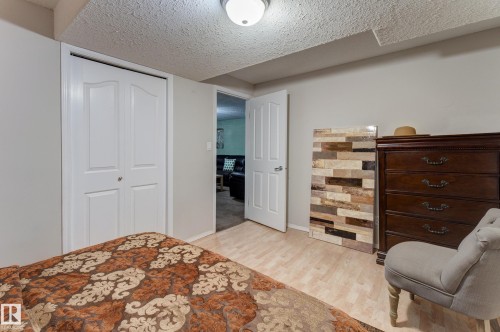 Light wood-finish flooring with white walls and bi-fold closet doors - 3519 22 Street Nw, Edmonton, AB 