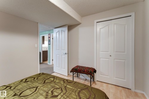 Laminate wood-finish flooring, white bifold closet doors, and a neutral wall color - 3519 22 Street Nw, Edmonton, AB 
