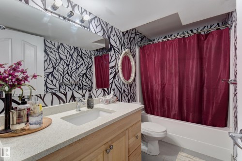 Bathroom featuring a white bathtub, a toilet, and a vanity with a light-colored countertop - 3519 22 Street Nw, Edmonton, AB 