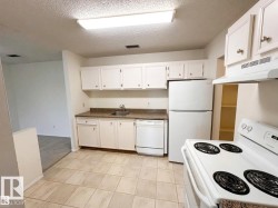 Kitchen featuring tiled flooring, white cabinetry, a built-in dishwasher, a white electric range, and a refrigerator - 