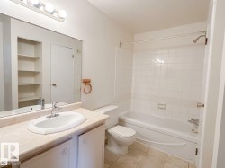 Vanity with integrated sink, chrome faucet, and ample storage cabinetry - 
