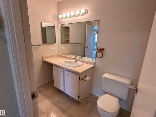 Bathroom with a vanity featuring a white sink, light-toned countertop, and white cabinetry - #132 2703 79 St Nw, Edmonton, AB 