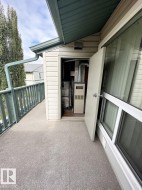 Outdoor balcony with textured flooring, a privacy railing, and a dedicated utility closet - 