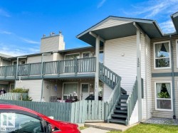 Multi-level exterior with light-colored siding, a prominent staircase, and dark-toned railings - 
