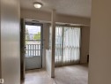 Entryway with neutral tile flooring, leading to a carpeted interior space - #132 2703 79 St Nw, Edmonton, AB 