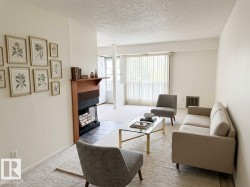 Living area featuring a wood mantel fireplace with a tiled hearth and a dedicated space for firewood storage - 
