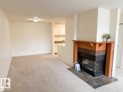Living area featuring a fireplace with a wood mantel, brick surround, and slate tile hearth - 