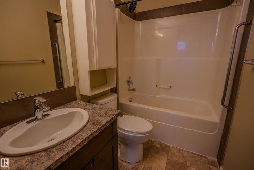 Bathroom featuring a vanity with an oval sink, laminate countertop, and dark wood-finish cabinetry - 122 142 Selkirk Place, Leduc, AB 