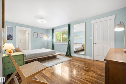 Hardwood flooring, light blue wall paint, white trim, recessed ceiling light, and a window with green drapes - 11006 64 Avenue Nw, Edmonton, AB 