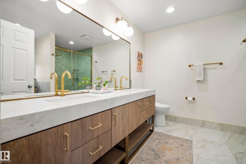 Dual vanity with integrated sinks, white countertop, wood-finish cabinetry, and gold-tone fixtures - 11006 64 Avenue Nw, Edmonton, AB 