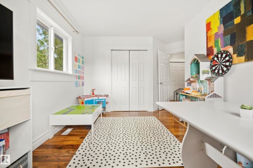 Hardwood flooring, white bi-fold closet doors, white trim, white door, and a multi-pane window - 11006 64 Avenue Nw, Edmonton, AB 