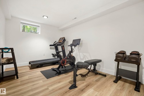 Recessed ceiling lighting illuminates a room with wood-finish flooring and white walls, featuring a high window - 11006 64 Avenue Nw, Edmonton, AB 
