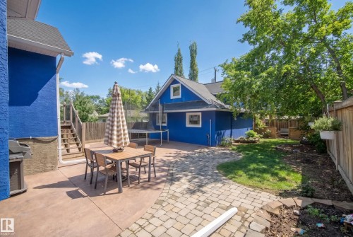 Expansive backyard featuring a stamped concrete patio, paver patio, detached auxiliary structure, and wood privacy fencing - 11006 64 Avenue Nw, Edmonton, AB 