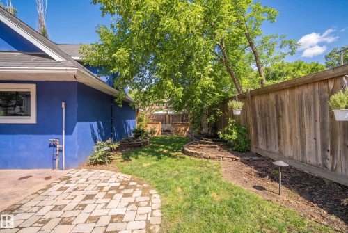 Exterior siding with a window, paver patio, wood fence, and landscaped garden beds - 11006 64 Avenue Nw, Edmonton, AB 