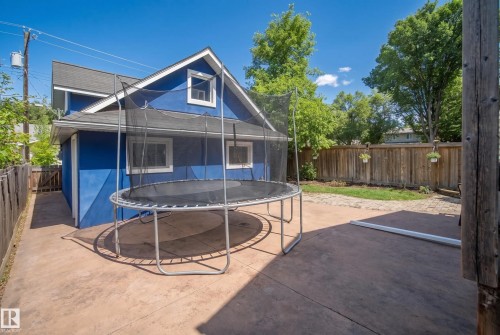 Expansive backyard featuring a stained concrete patio, a privacy fence, and mature trees - 11006 64 Avenue Nw, Edmonton, AB 